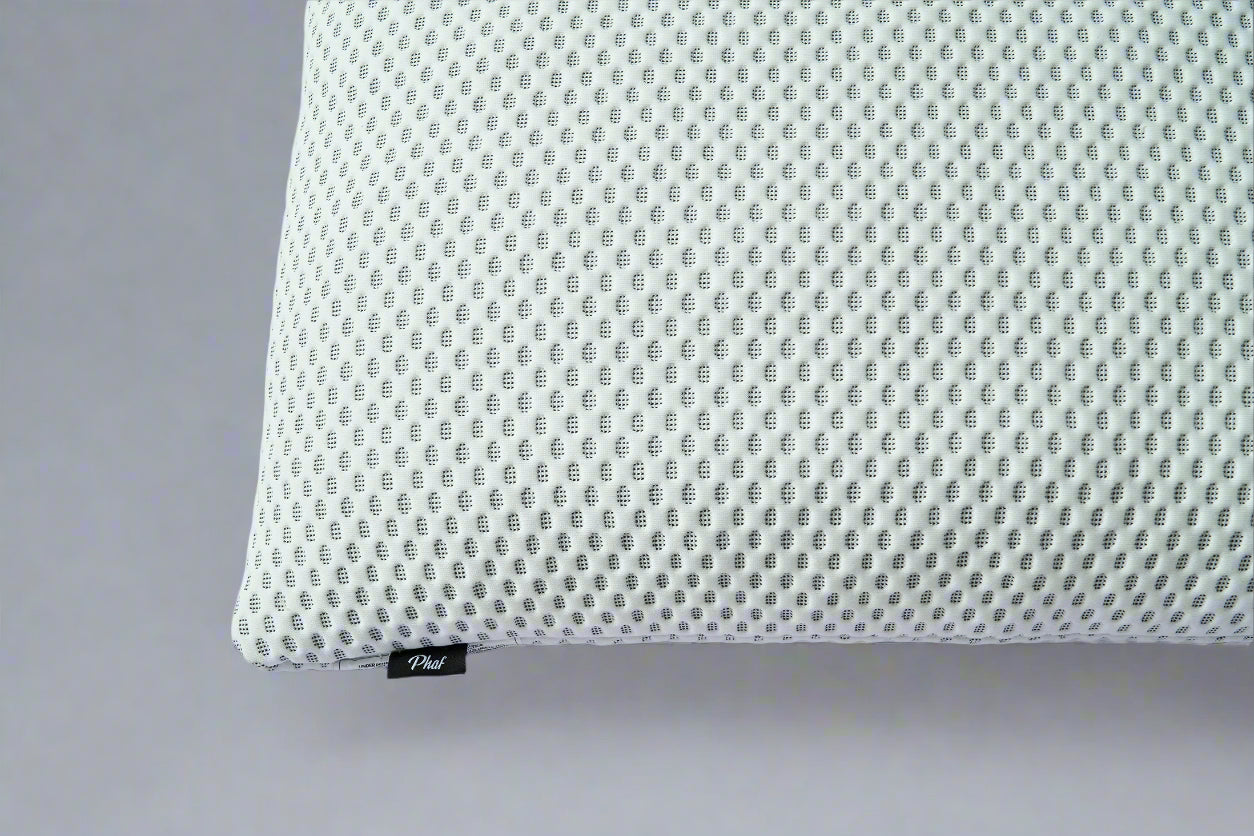 White  textured pillow with a brand label "PHAF" on a gray background